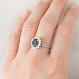 Anello a margherita in oro bianco 18K con zaffiro (1.30ct ca.) e diamanti di taglio brillante (0.44ctw ca.), anni ‘70