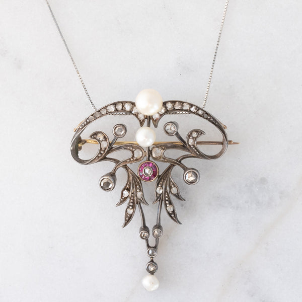 Collana con pendente/spilla Art Nouveau in oro giallo 18K e argento con diamanti di taglio rosetta (0.50ctw ca.), rubini e perle bianche, anni ‘10/‘20
