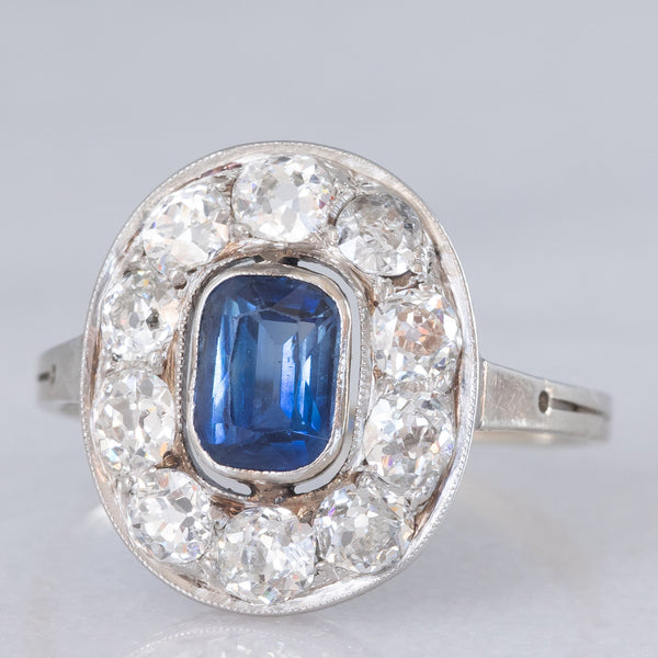 Anello a margherita antico in oro bianco con zaffiro (0.70ct ca.) e diamanti di taglio vecchia miniera (1ctw ca.), anni ‘20/‘30