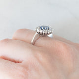 Anello a margherita in oro bianco 18K con zaffiro azzurro (0.80ct ca.) e diamanti di taglio brillante (0.70ctw ca.), anni ‘70/‘80