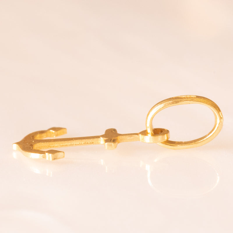 Collana con catenina in argento dorato e con tre ciondoli a forma di delfino in oro giallo 18K, di ancora in oro giallo 18K e di tartaruga in oro giallo 14K