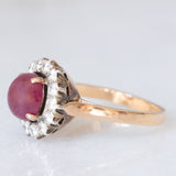 Anello a margherita vintage in oro giallo e bianco 14K con rubino (2.60ct ca.) e diamanti di taglio brillante (0.70ctw ca.), anni ‘60