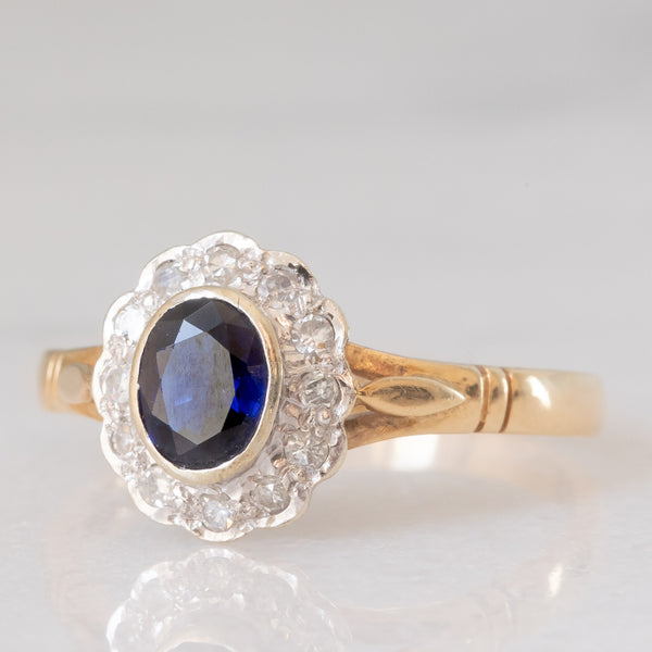 Anello a margherita vintage in oro giallo e bianco 9K con zaffiro (0.60ct ca.) e diamanti (0.12ctw ca.), anno 1991