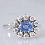 Anello a margherita in oro bianco 18K con zaffiro azzurro (0.80ct ca.) e diamanti di taglio brillante (0.70ctw ca.), anni ‘70/‘80