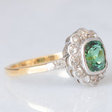 Anello a margherita antico in oro giallo 18K con tormalina verde (1ct ca.) e diamanti di taglio vecchia miniera (0.50ctw ca.), anni ‘20/‘30