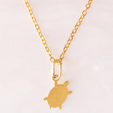 Collana con catenina in argento dorato e con tre ciondoli a forma di delfino in oro giallo 18K, di ancora in oro giallo 18K e di tartaruga in oro giallo 14K