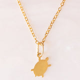 Halskette mit vergoldeter Silberkette und drei Anhängern in Form eines Delfins aus 18-karätigem Gelbgold, eines Ankers aus 18-karätigem Gelbgold und einer Schildkröte aus 14-karätigem Gelbgold