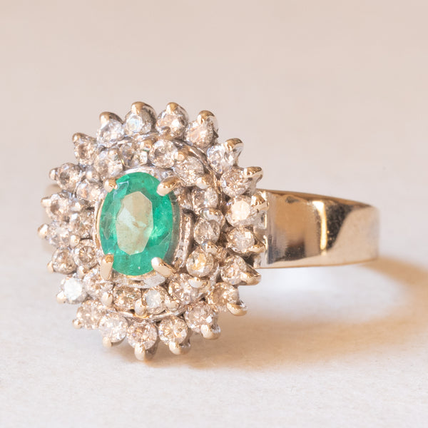 Anello a margherita vintage in oro bianco 18K con smeraldo (0.50ct ca.) e diamanti (0.53ctw ca.), anni ‘60/‘70