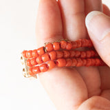 Vintage dreisträngiges Armband aus orangefarbenen Korallenperlen mit Verschluss aus 14 Karat Gelbgold und orangefarbener Koralle, 60er Jahre