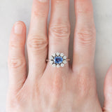 Anello a margherita in oro bianco 18K con zaffiro azzurro (0.80ct ca.) e diamanti di taglio brillante (0.70ctw ca.), anni ‘70/‘80