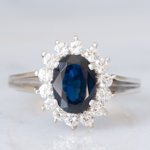 Anello a margherita in oro bianco 18K con zaffiro (1.30ct ca.) e diamanti di taglio brillante (0.44ctw ca.), anni ‘70