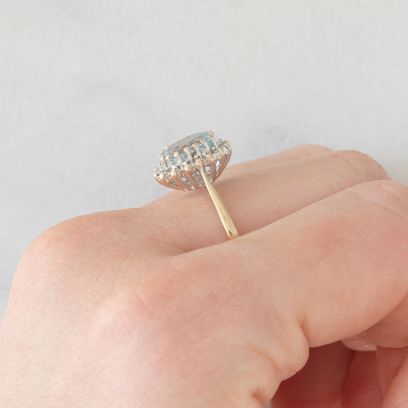 Anello a margherita vintage in oro giallo e bianco 9K con topazio azzurro (1.60ct ca.) e diamanti (0.16ctw ca.), anni ‘80
