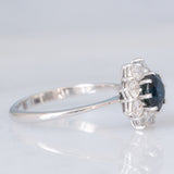 Anello a margherita vintage in oro bianco 18K con zaffiro (1.20ct ca.) e diamanti di taglio brillante (0.80ctw ca.), anni ‘70