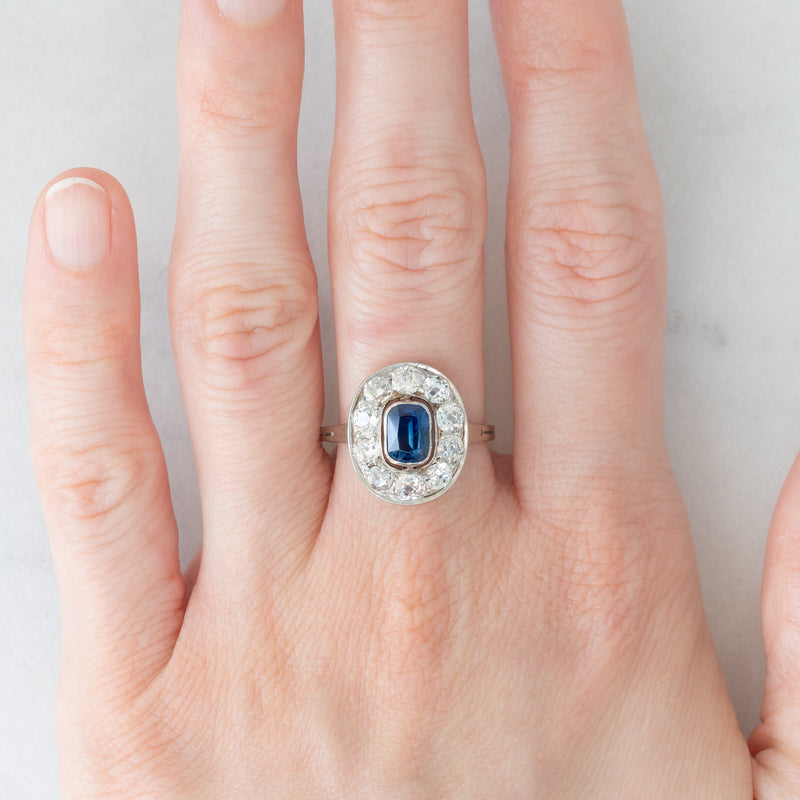 Anello a margherita antico in oro bianco con zaffiro (0.70ct ca.) e diamanti di taglio vecchia miniera (1ctw ca.), anni ‘20/‘30