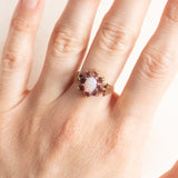 Vintage-Gänseblümchenring aus 9-karätigem Gelbgold mit Opal (ca. 0.30 ct) und synthetischen Rubinen (ca. 0.50 ctw), Jahr 1973–1974