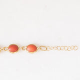 Pulseira vintage em ouro amarelo 18K com coral laranja e fecho decorado com um pingente de chifre da sorte, década de 70