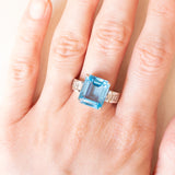 Anel de coquetel vintage em ouro branco 18K com topázio azul (aprox. 8.50 ct) e diamantes lapidação baguete (aprox. 0.80 ctw), década de 80