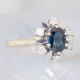 Anello a margherita vintage in oro bianco 14K con zaffiro (1ct ca.) e diamanti (0.24ctw ca.), anni ‘60/‘70