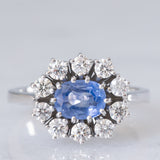 Anello a margherita in oro bianco 18K con zaffiro azzurro (0.80ct ca.) e diamanti di taglio brillante (0.70ctw ca.), anni ‘70/‘80