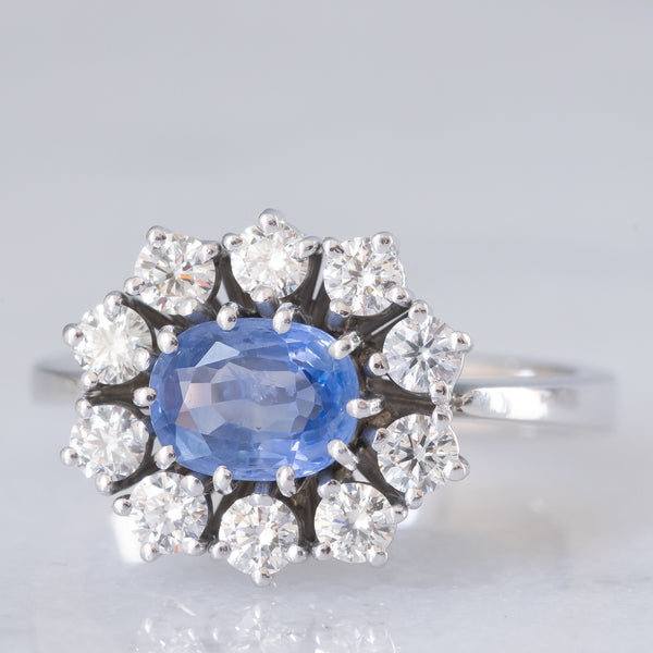 Anello a margherita in oro bianco 18K con zaffiro azzurro (0.80ct ca.) e diamanti di taglio brillante (0.70ctw ca.), anni ‘70/‘80