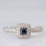 Anello a margherita vintage in oro bianco 9K con zaffiro di taglio carré (0.20ct ca.) e diamanti (0.38ctw ca.), anni ‘90/anni ‘2000