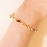 Bracciale vintage in oro giallo 18K con granati, ametiste, acquamarina, spinello blu sintetico e zaffiro bianco, anni ‘70