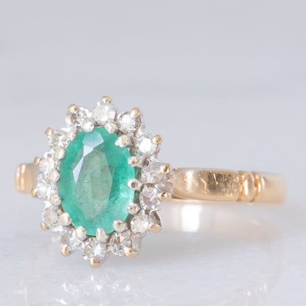 Anello a margherita vintage in oro giallo e bianco 9K con smeraldo (0.70ct ca.) e diamanti (0.20ctw ca.), anni ‘80