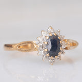 Anello a margherita vintage in oro giallo e bianco 9K con zaffiro (0.60ct ca.) e diamanti (0.06ctw ca.), anno 1988