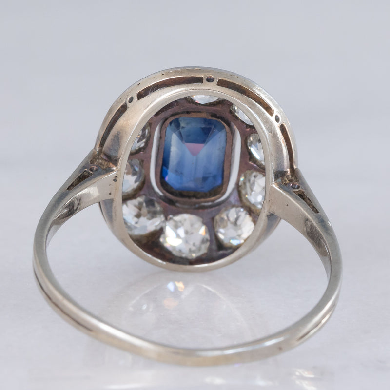 Anello a margherita antico in oro bianco con zaffiro (0.70ct ca.) e diamanti di taglio vecchia miniera (1ctw ca.), anni ‘20/‘30
