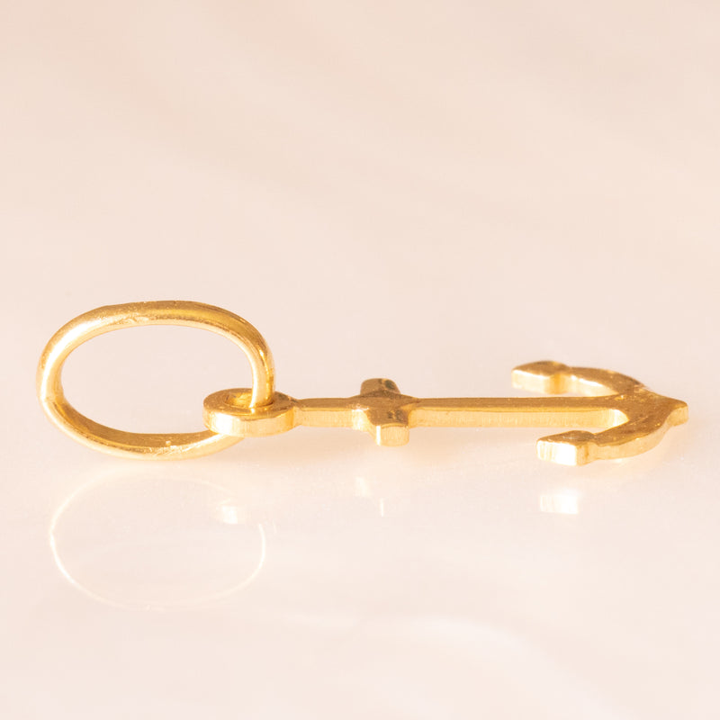 Collana con catenina in argento dorato e con tre ciondoli a forma di delfino in oro giallo 18K, di ancora in oro giallo 18K e di tartaruga in oro giallo 14K