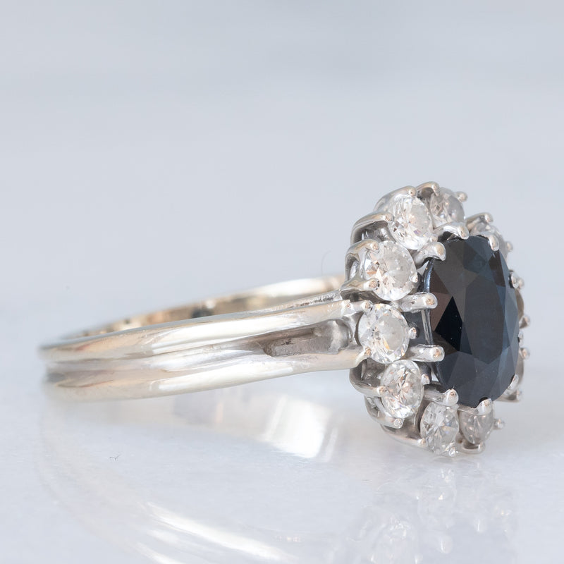 Anello a margherita vintage in oro bianco 18K con zaffiro (1ct ca.) e diamanti di taglio brillante (0.60ctw ca.), anni ‘70