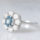 Anello a margherita vintage in oro bianco 14K con zaffiro (0.75ct ca.) e diamanti di taglio brillante (0.64ctw ca.), anni ‘60/‘70