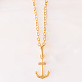 Collana con catenina in argento dorato e con tre ciondoli a forma di delfino in oro giallo 18K, di ancora in oro giallo 18K e di tartaruga in oro giallo 14K