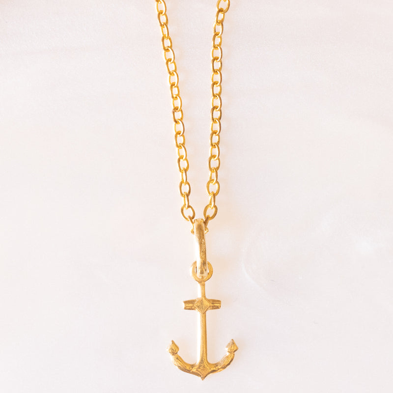 Collana con catenina in argento dorato e con tre ciondoli a forma di delfino in oro giallo 18K, di ancora in oro giallo 18K e di tartaruga in oro giallo 14K