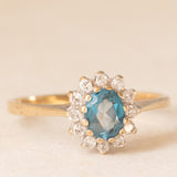 Anello a margherita vintage in oro giallo e bianco 9K con topazio azzurro (0.40ct ca.) e diamanti (0.12ctw ca.), anni ‘90
