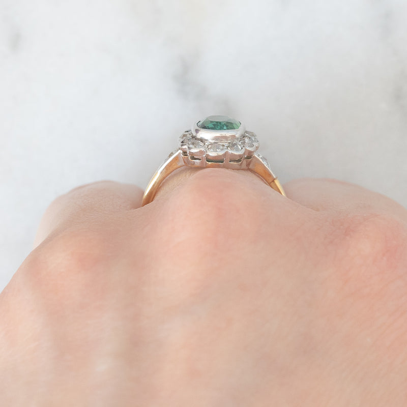 Anello a margherita antico in oro giallo 18K con tormalina verde (1ct ca.) e diamanti di taglio vecchia miniera (0.50ctw ca.), anni ‘20/‘30