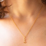 Collana con catenina in argento dorato e con tre ciondoli a forma di delfino in oro giallo 18K, di ancora in oro giallo 18K e di tartaruga in oro giallo 14K