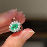 Anello a margherita in oro bianco 18K con smeraldo (1ct ca.) e diamanti di taglio brillante (0.50ctw ca.), anni ‘60