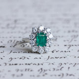 Vintage Gänseblümchenring aus 18 Karat Weißgold mit Smaragd (ca. 0.70 ct) und Diamanten im Brillantschliff (ca. 1.3 ct), 50er / 60er Jahre