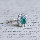 Vintage Gänseblümchenring aus 18 Karat Weißgold mit Smaragd (ca. 0.70 ct) und Diamanten im Brillantschliff (ca. 1.3 ct), 50er / 60er Jahre