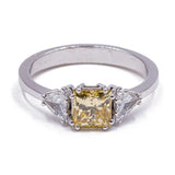 Anillo de oro blanco de 18 quilates con un elegante diamante amarillo (1 ct) y diamantes laterales triangulares (0.60 quilates)