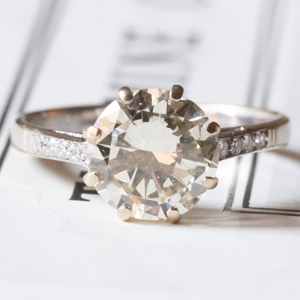 Anello moderno in oro bianco 18K con diamante centrale di taglio brillante (2.99ct ca.) e diamanti laterali (0.08ctw ca.)