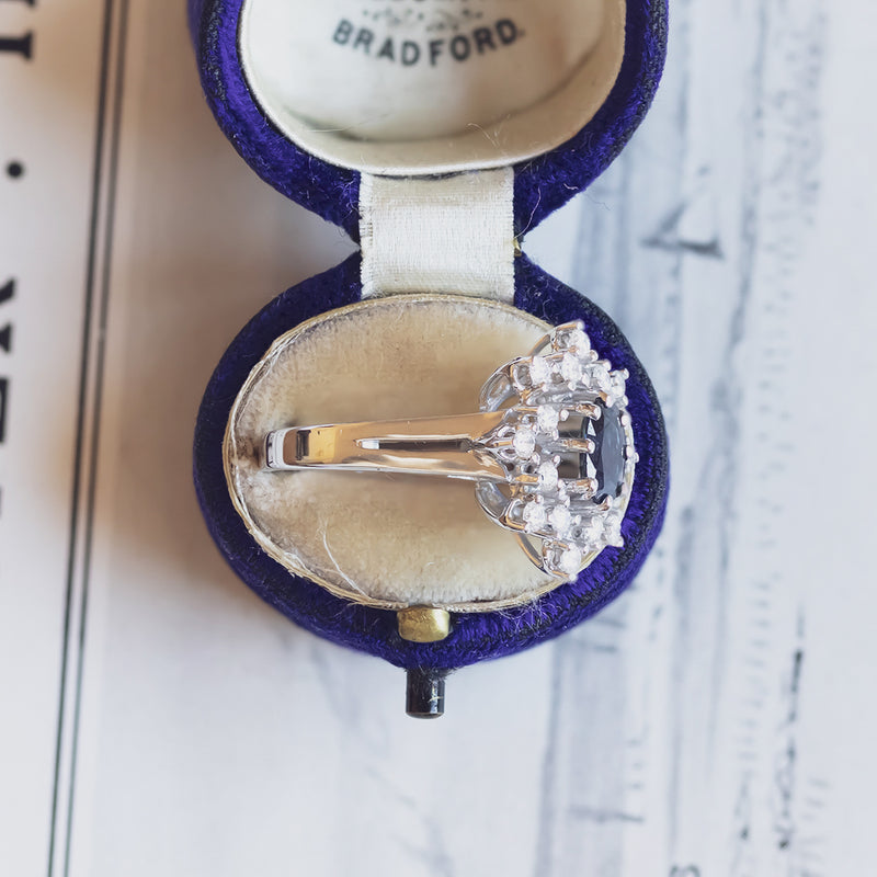 Anello a margherita vintage in oro bianco 14K con zaffiro (1.10ct ca.) e diamanti (0.48ctw ca.), anni ‘60/‘70
