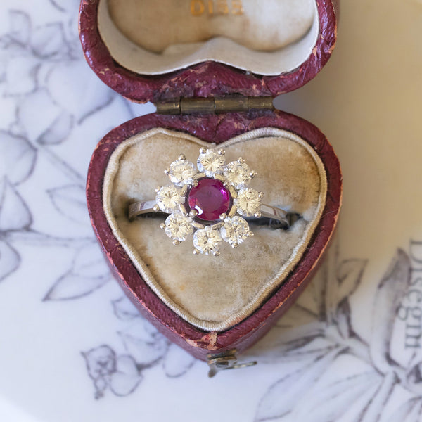 Anello a margherita vintage in oro bianco 18K con rubino (1ct ca.) e diamanti (1.20ctw ca.), anni ‘70